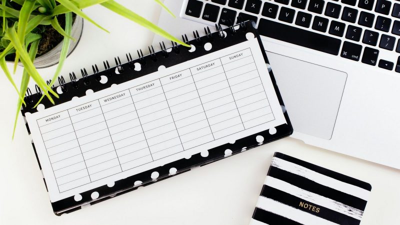 Kalendarz, komputer i notes na biurku